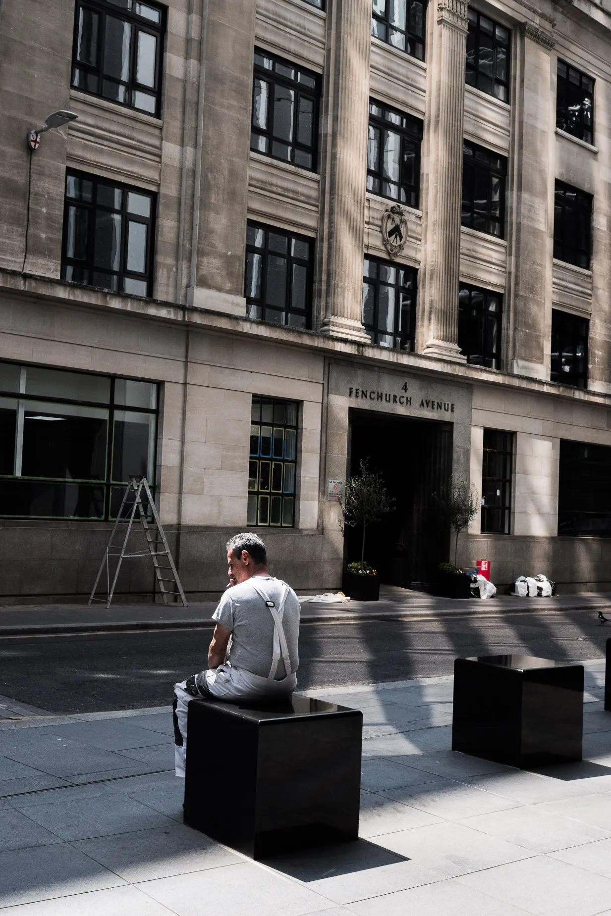 Street scene of man smoking a cigarette on his lunch break