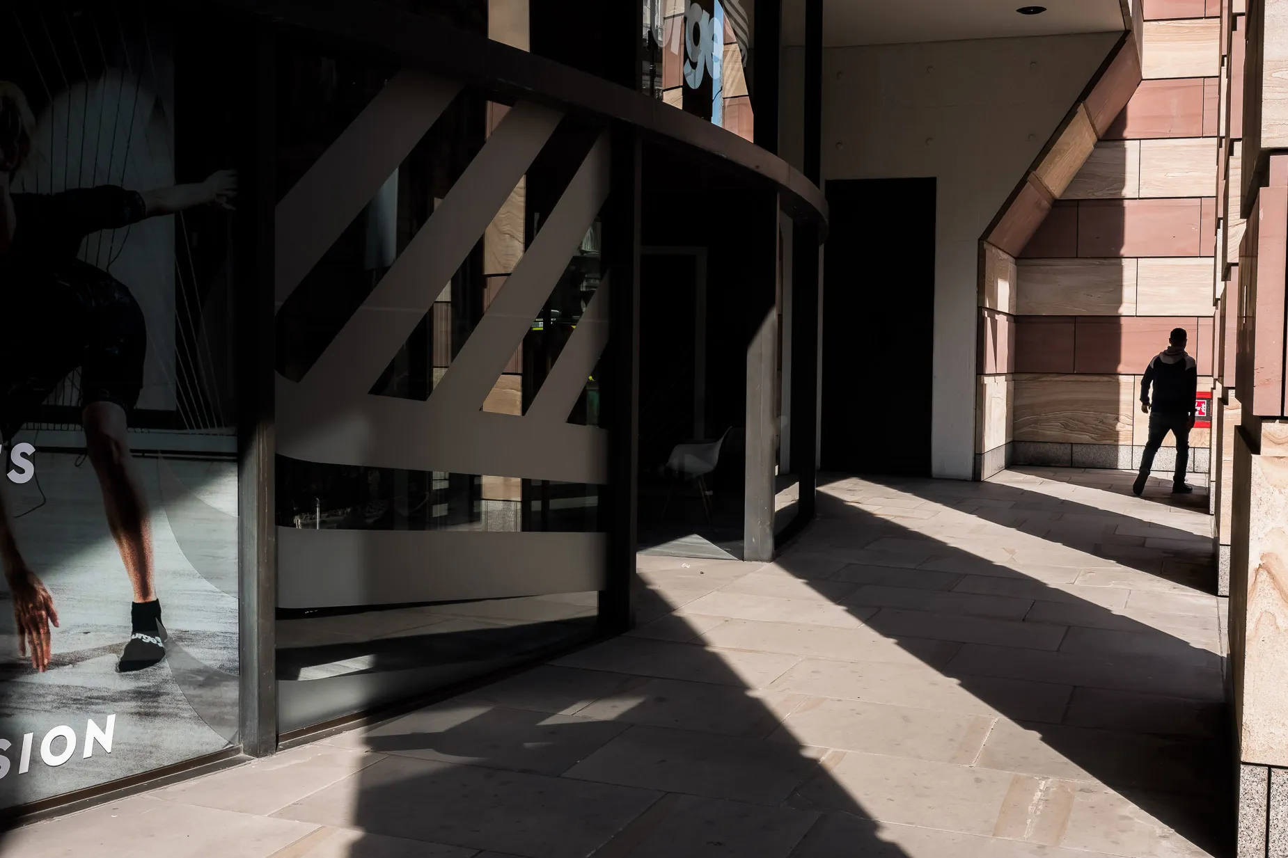 Man silhouette walking through a building archway