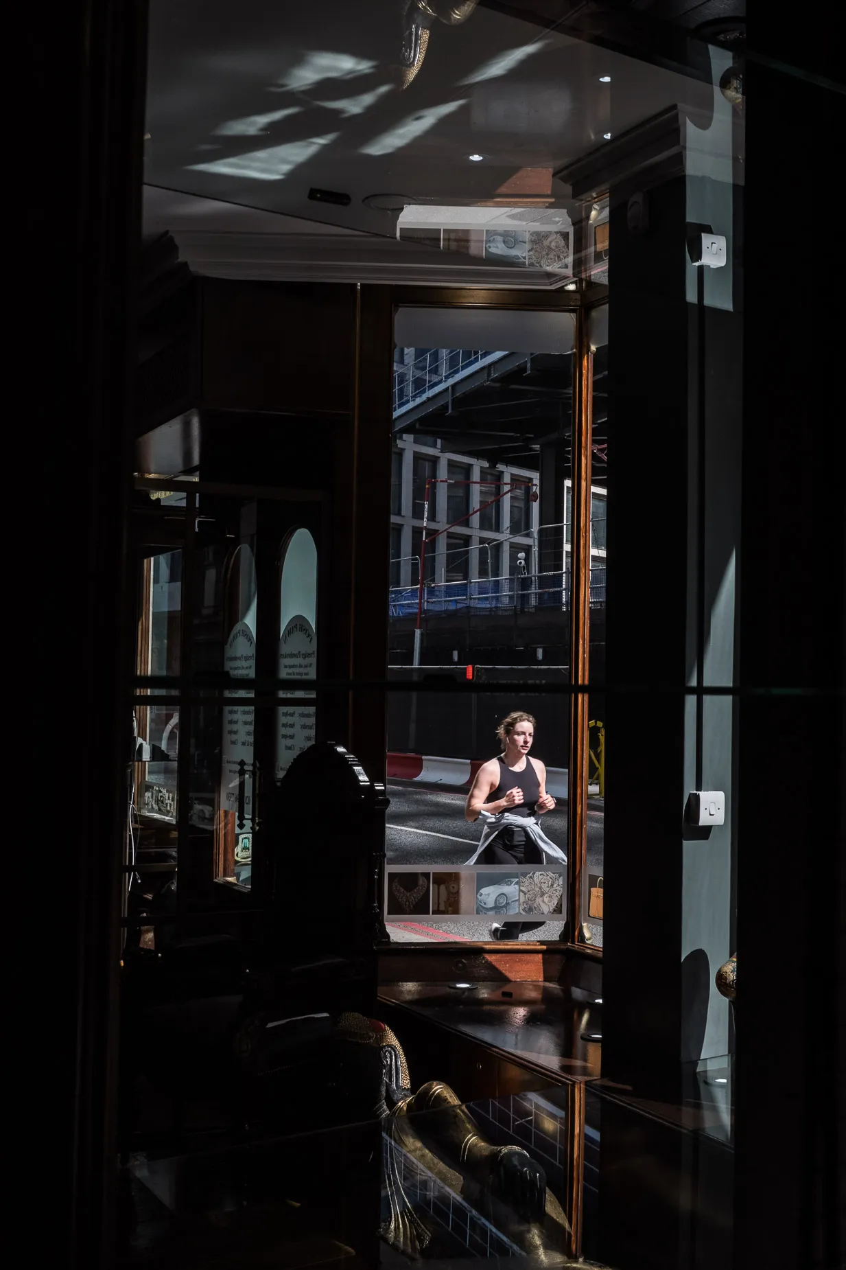 Woman jogging on lunch break scene through a glass store window