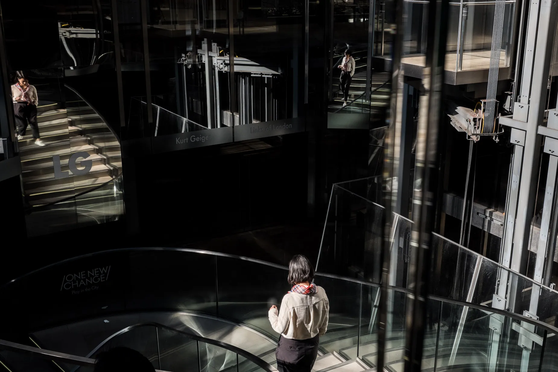 Reflections steel and glass, woman on staircase
