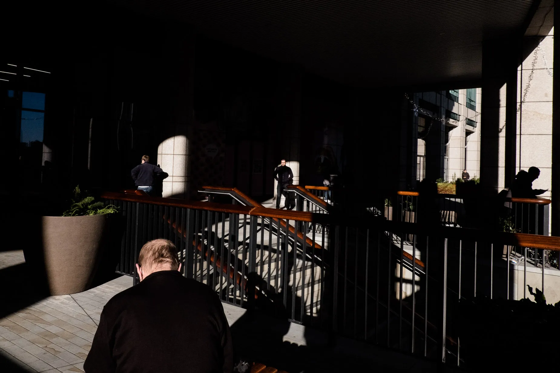 Light & Shadow scene of men in Bishops Gate walk, one man silhouettes against a stone wall