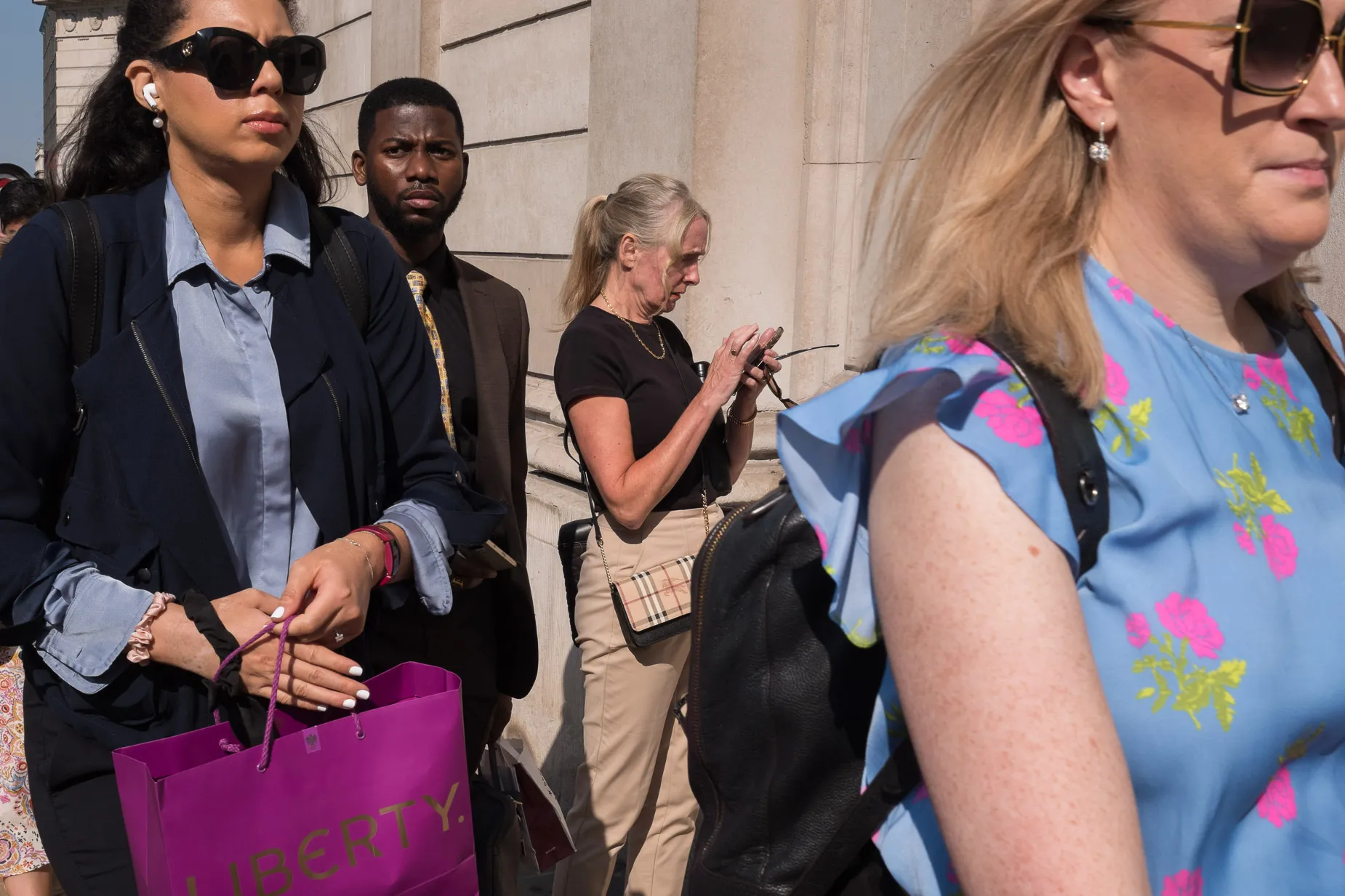 Morning commuters, man amongst three women outside the bank of England,