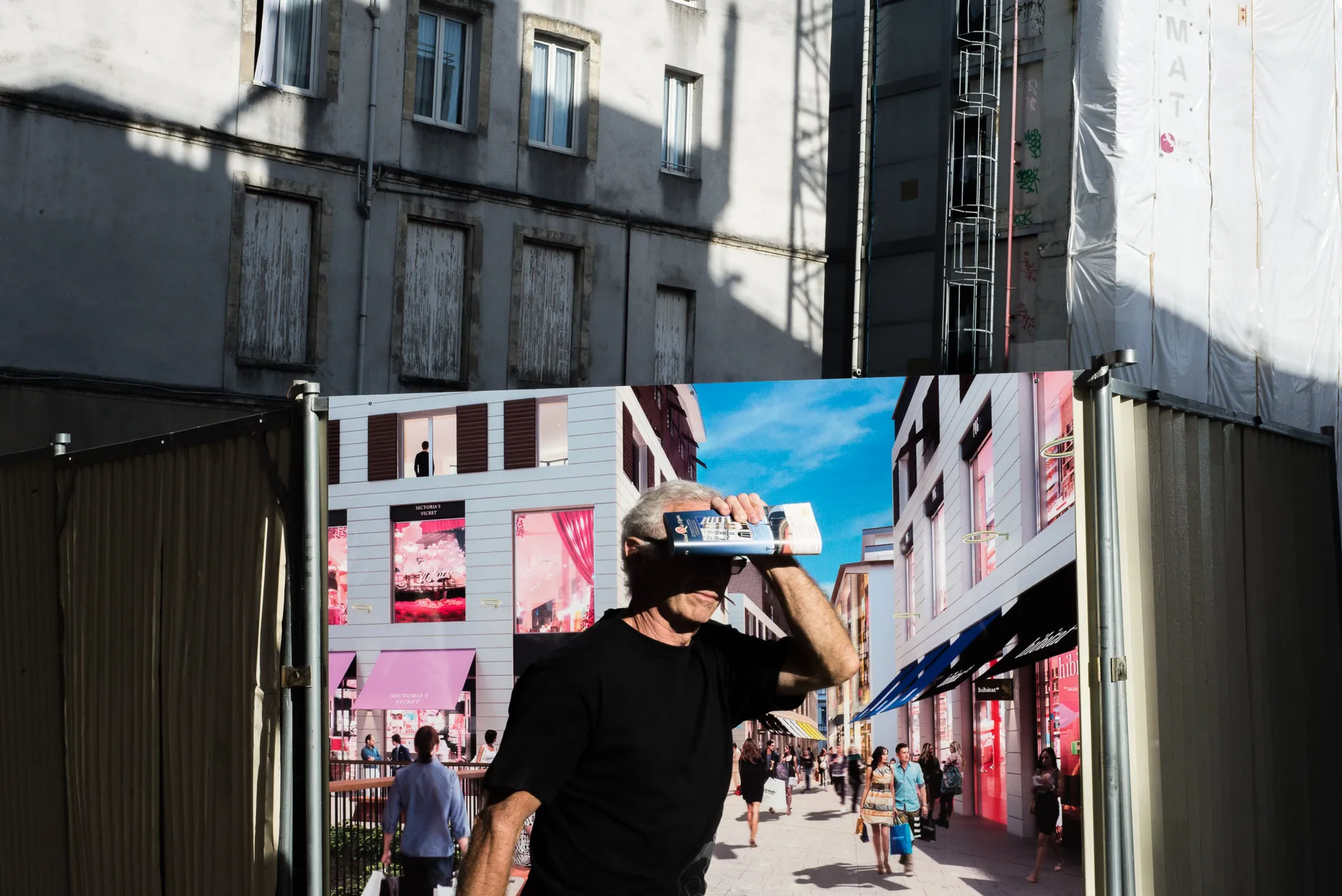 Man shades face from direct sunlight against colourful background