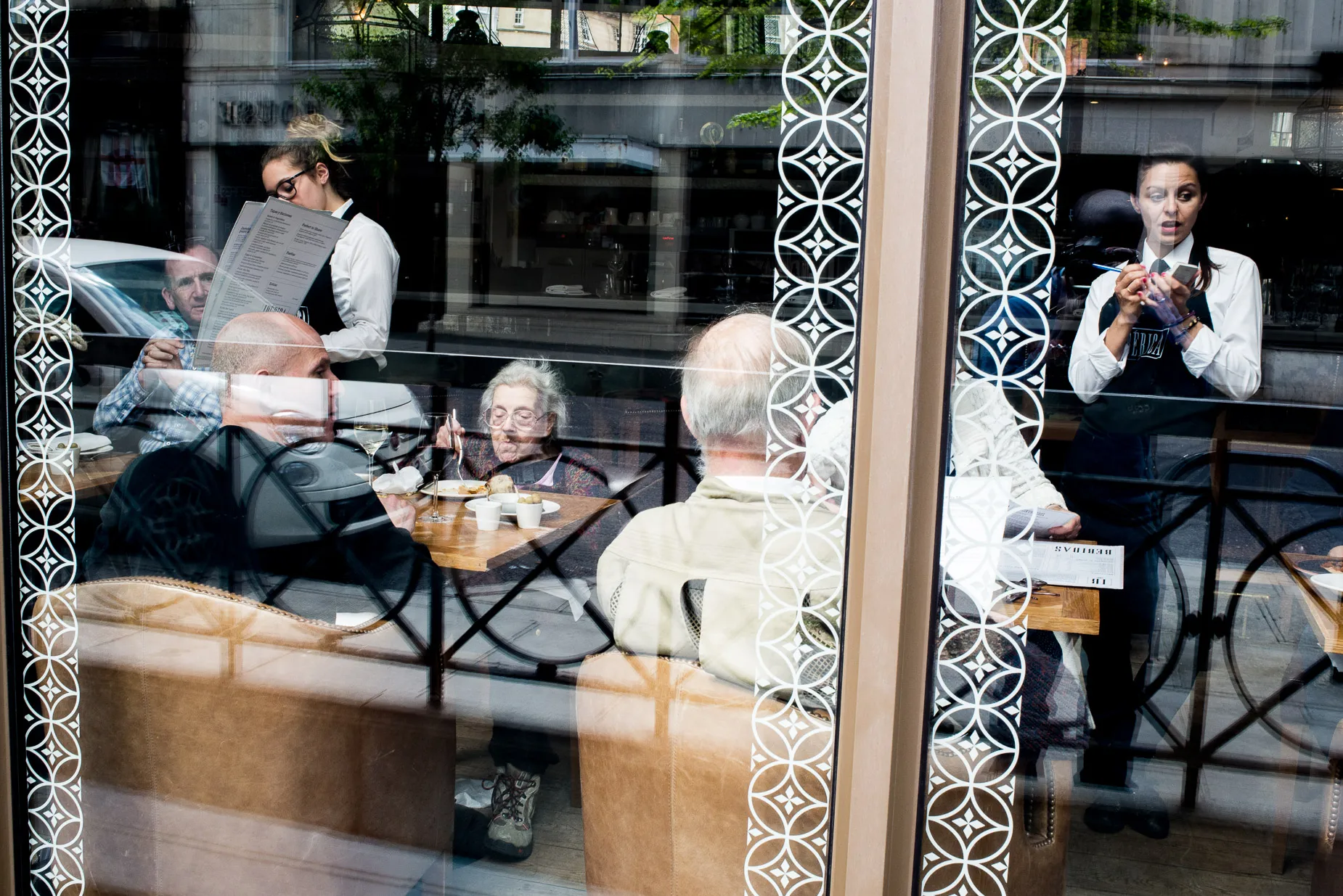 Restaurant scene showing elderly woman focusing in food between waitress