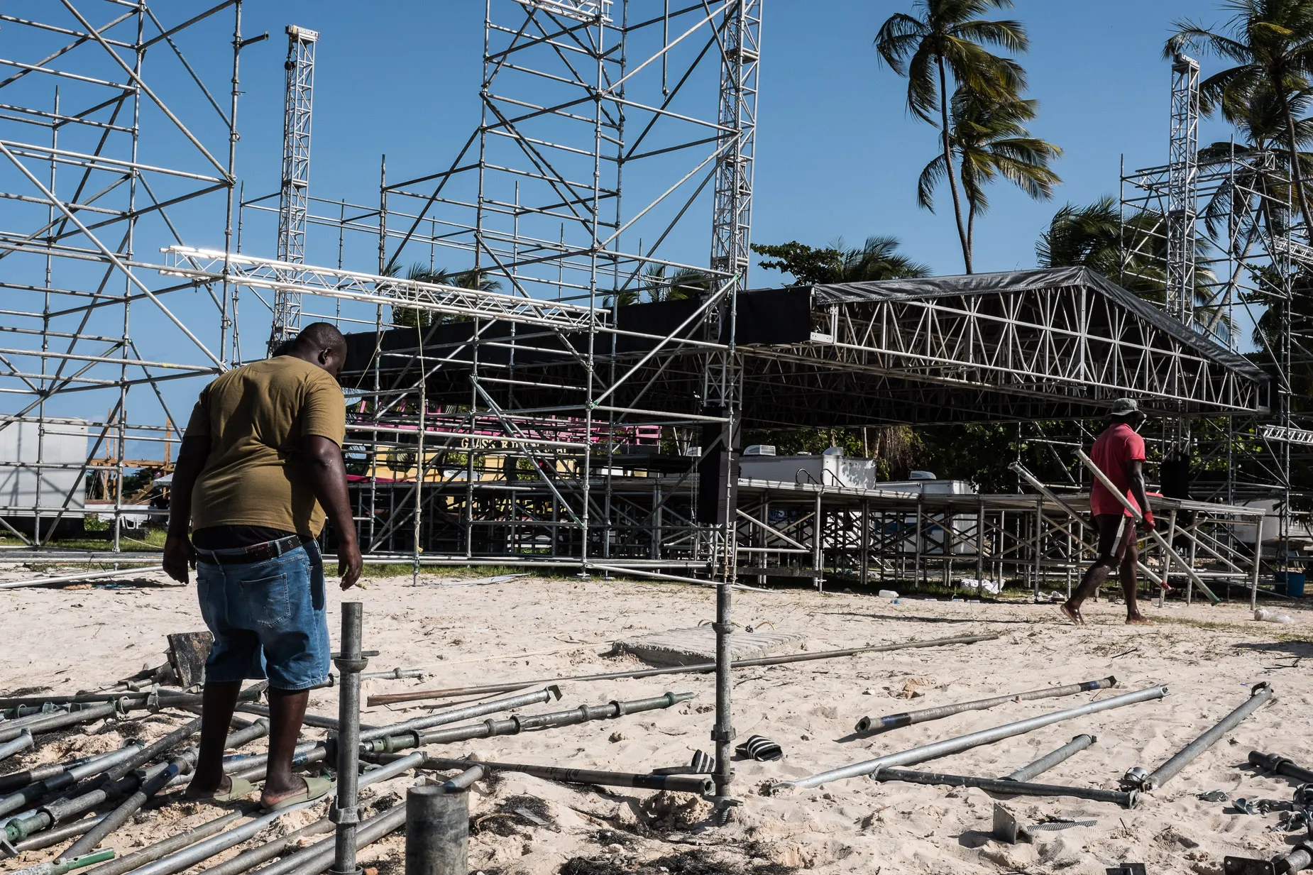 Men dismantling scaffold on beach in Scarborough Tobago